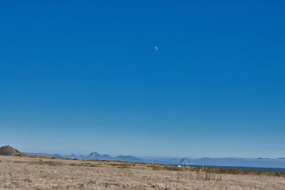 Scenic view of desert against clear blue sky