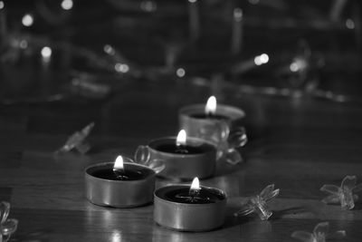 Close-up of lit tea light candles on table