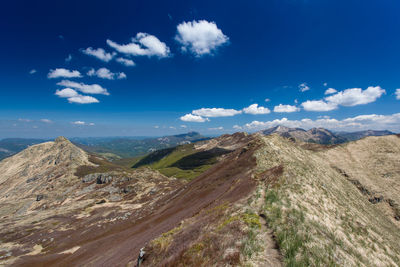 Scenic view of mountains against blue sky