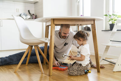 Father and daughter assembling table