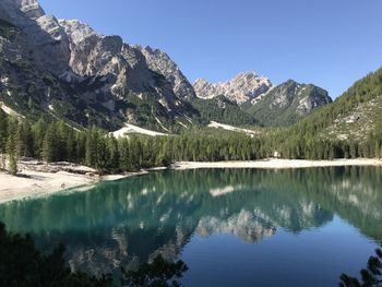 Scenic view of lake and mountains against clear blue sky