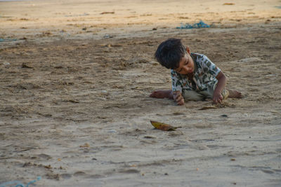 Boy playing on sand at beach