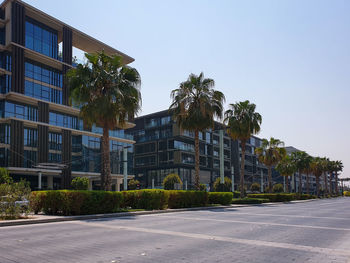 Street by buildings against clear sky