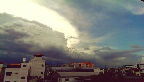 Buildings against cloudy sky