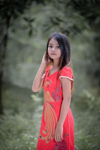 Young woman looking away while standing outdoors