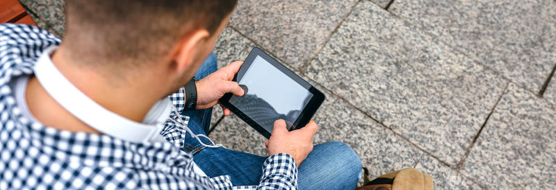 High angle view of man using digital tablet in city