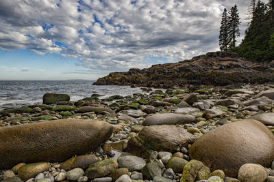 Rocks by sea against sky