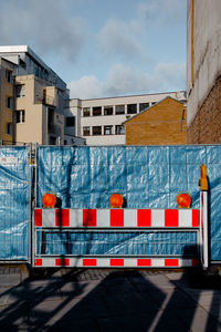 Barricade by fence against buildings at construction site in city