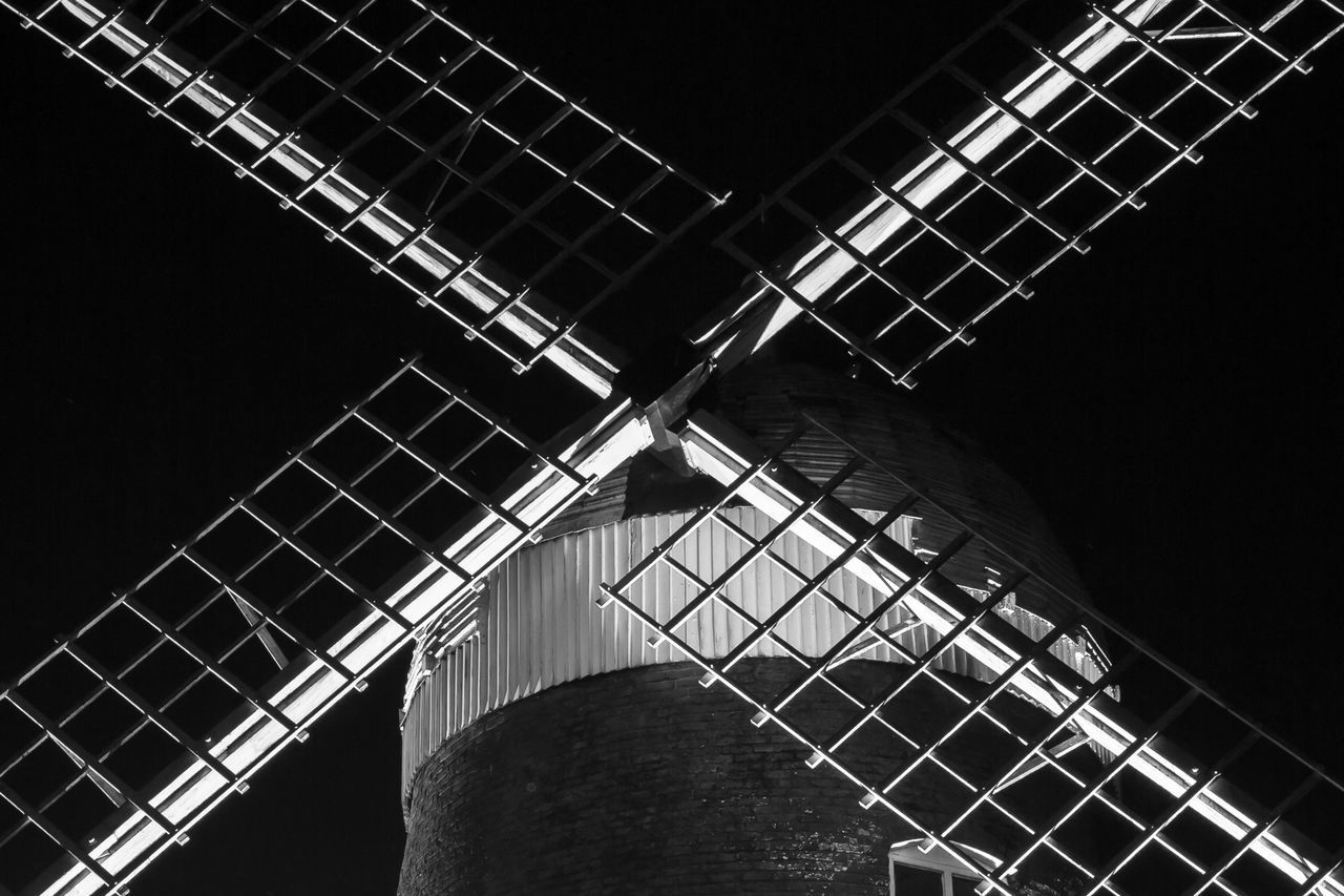 LOW ANGLE VIEW OF ILLUMINATED SKYSCRAPER AGAINST SKY AT NIGHT