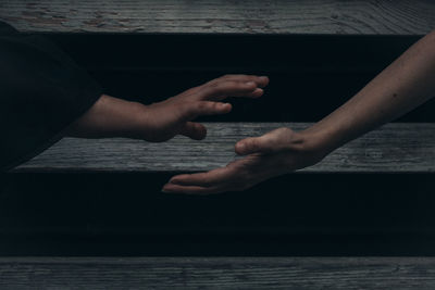 Midsection of couple hands on sea shore