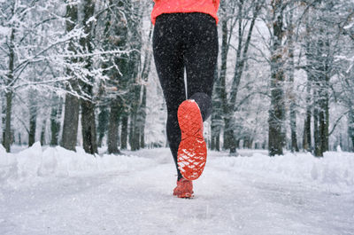 Running woman, girl runner on snow in park winter day. run, sport concept, leisure and freedom.