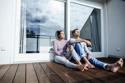 Mature couple relaxing in balcony on sunny day