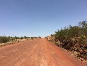 Road amidst trees against clear sky