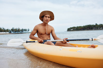 Portrait of young woman kayaking in lake