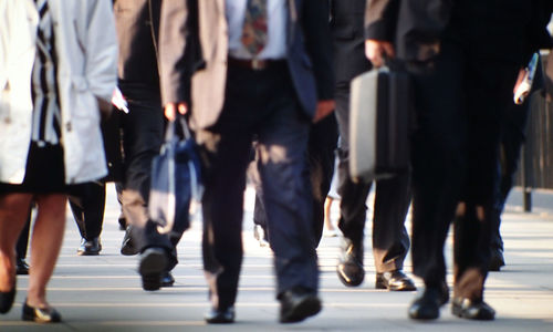 Low section of people walking on street