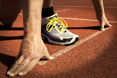 Low section of man standing at starting line