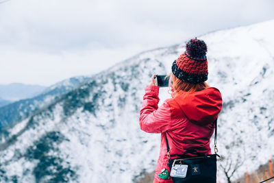 Midsection of person in snow against mountains