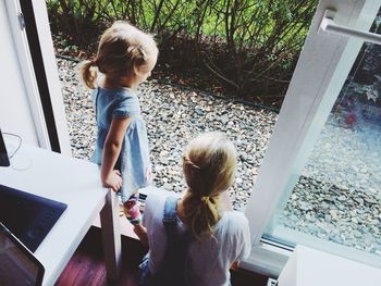 High angle view of mother with daughter by window at home