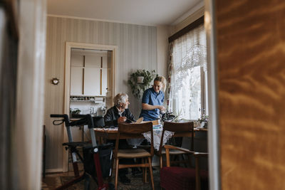 Smiling female caregiver with senior man at home