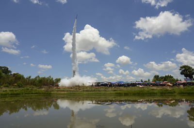 Rocket at lakeshore against sky