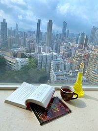 High angle view of book on table against buildings in city
