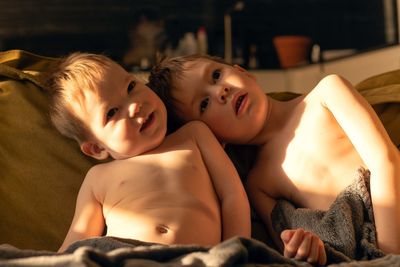 Portrait of cute baby boy lying on bed at home