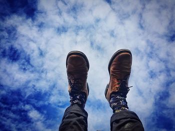 Low section of man against cloudy sky