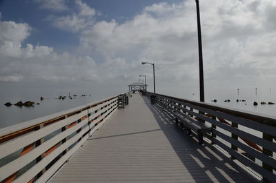 Pier on footbridge against sky