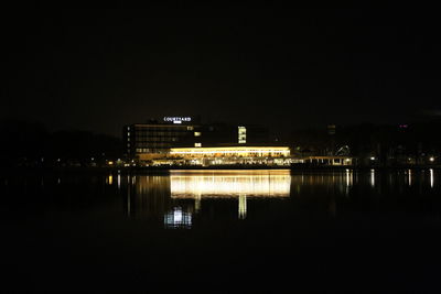 Reflection of buildings in lake at night