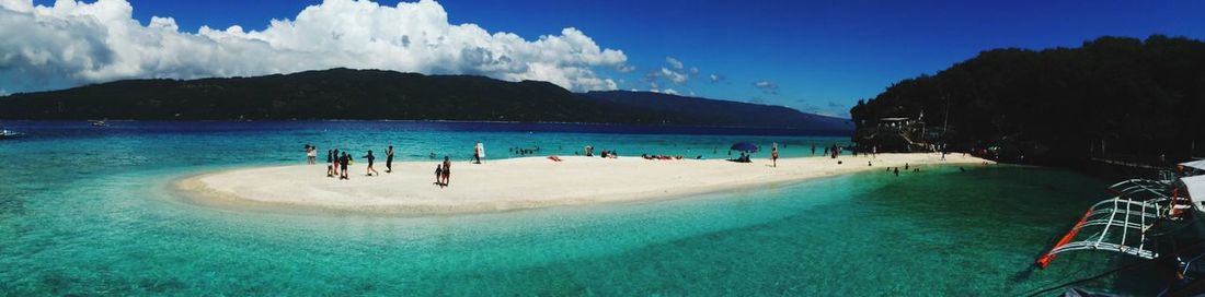 People at beach against sky