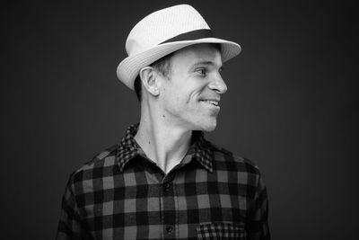 Portrait of smiling mid adult man against black background