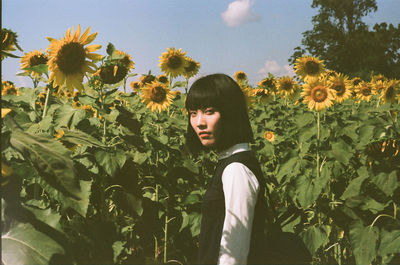 Portrait of woman standing in sunflower field
