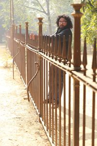 Portrait of man standing against railing