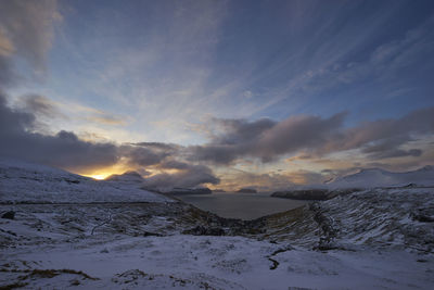 Scenic view of snow covered landscape against sky during sunset