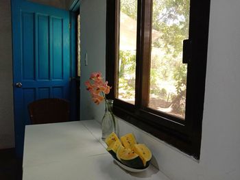 Flower vase on table by window