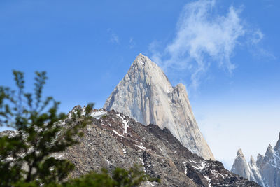 Low angle view of snowcapped mountain against blue sky