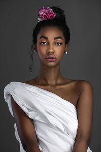 Close-up portrait of young woman against black background