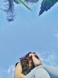 Low angle view of woman relaxing against sky