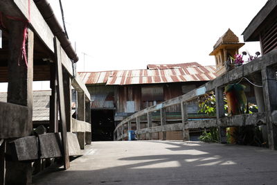 Footpath amidst buildings in city against clear sky