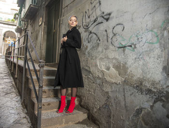 Portrait of woman standing against wall