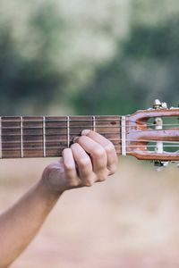 Midsection of man playing guitar