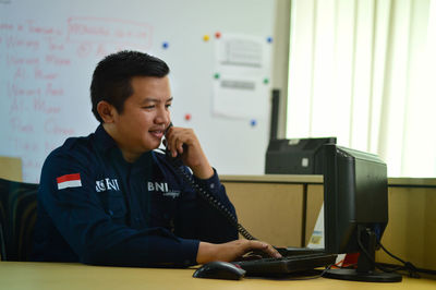 Young man sitting on mobile phone