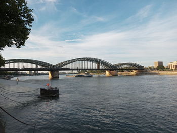 Bridge over river in city against sky