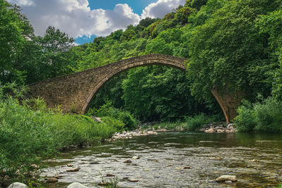 Arch bridge over river against sky