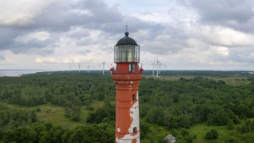 Lighthouse by sea against sky