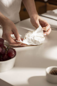 Cropped hand of person preparing food on table