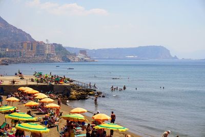 People at beach against sky