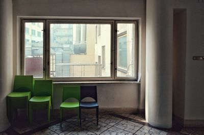 Empty chairs and table by window at home