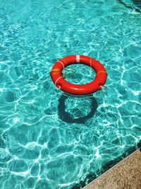 High angle view of red life belt floating on swimming pool