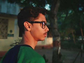 Side view of young man wearing eyeglasses while looking away